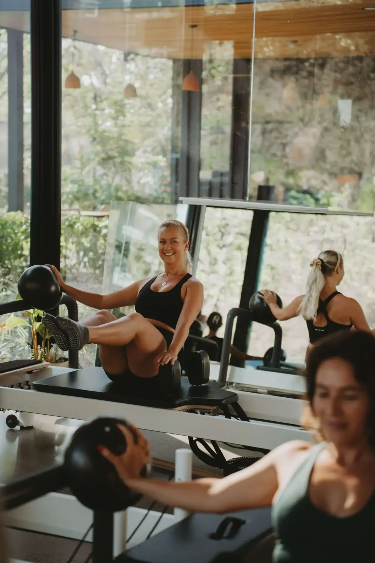 Relaxed women exercising with kettlebells in a modern gym at Opulencia, Nosara, Costa Rica, promoting fitness and wellness.